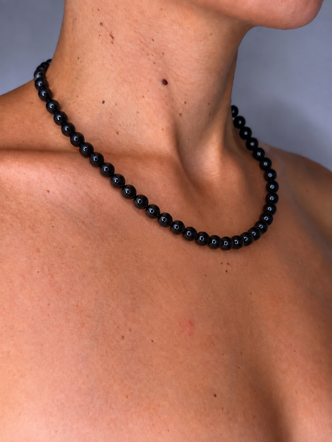 collier en obsidienne noire porté à même la peau